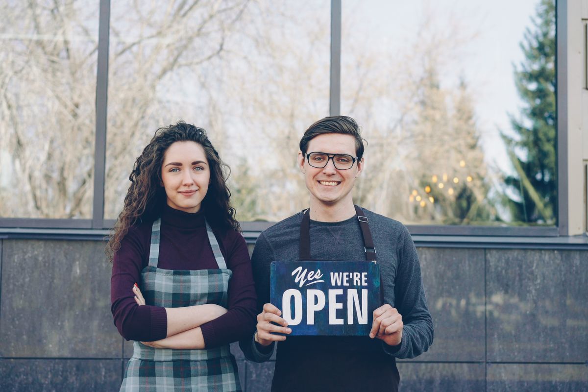 Deux commerçants devant leur boutique