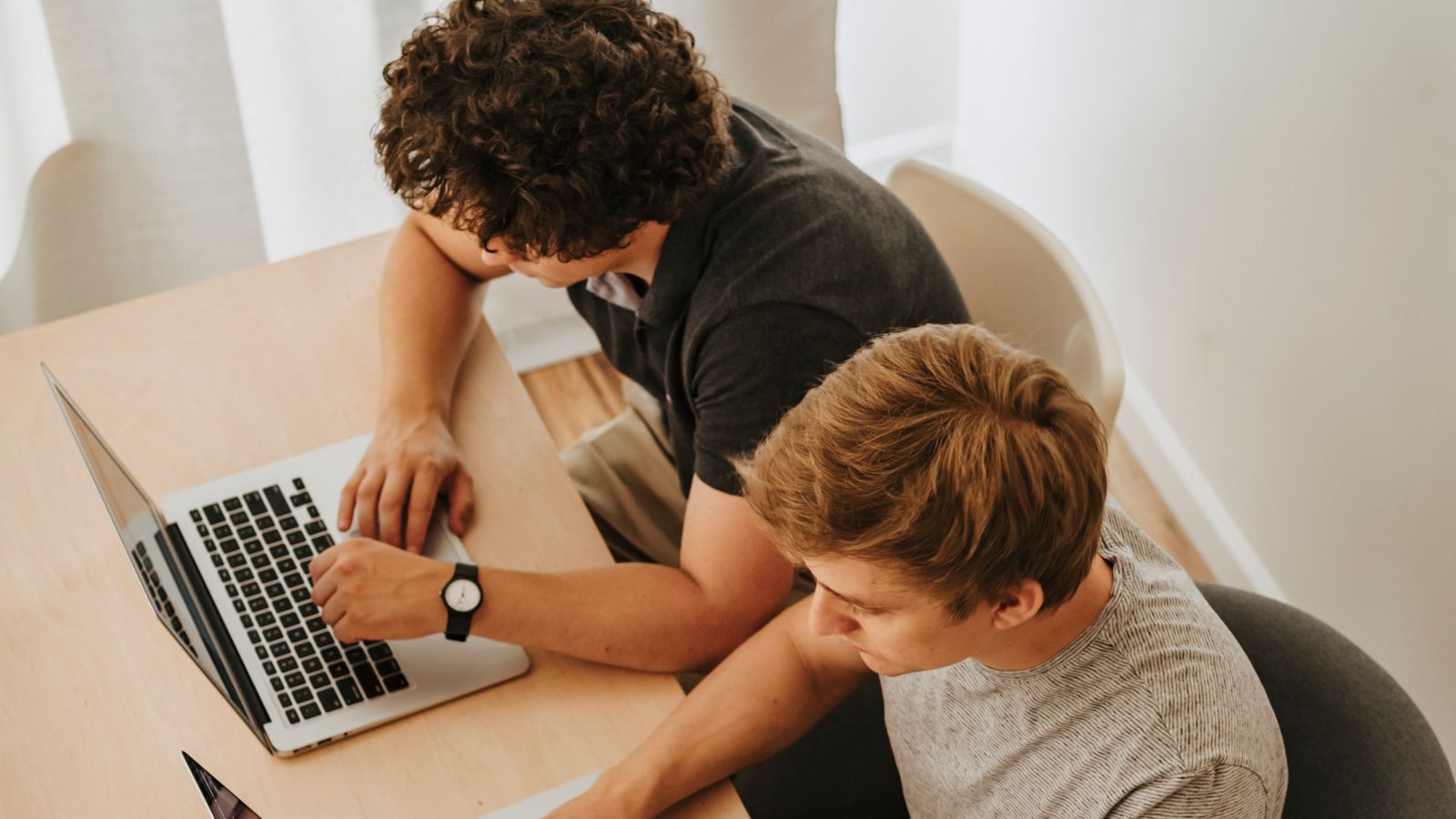 Two people working together on laptops