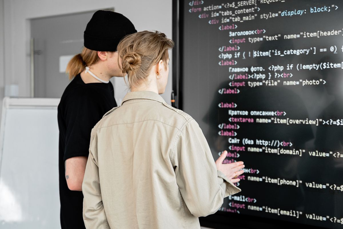 Two people reviewing a system on a large screen