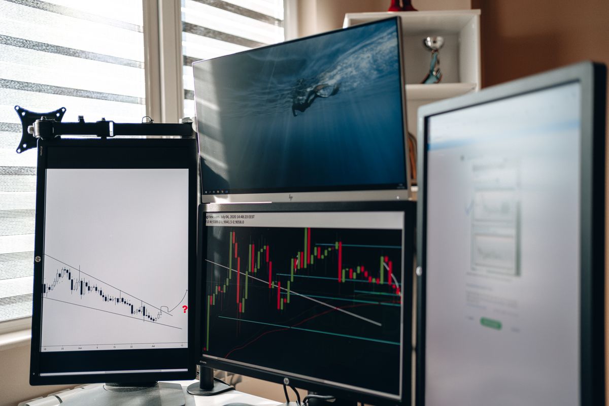 A multi-monitor desk with market data